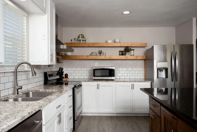 a kitchen with stainless steel appliances granite countertop a sink stove and refrigerator