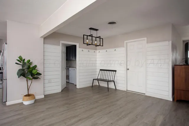 a view of a livingroom with wooden floor and a potted plant
