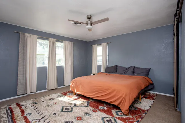 a bedroom with a large bed and a chandelier
