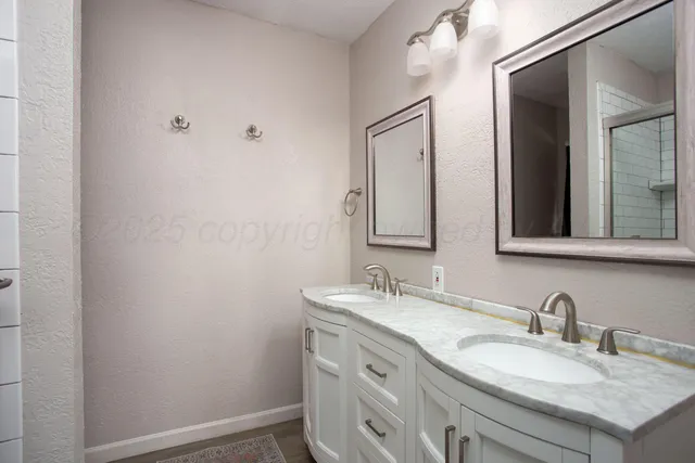 a bathroom with a granite countertop sink vanity and mirror