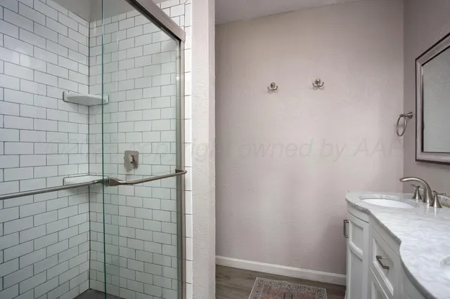 a bathroom with a granite countertop sink and shower
