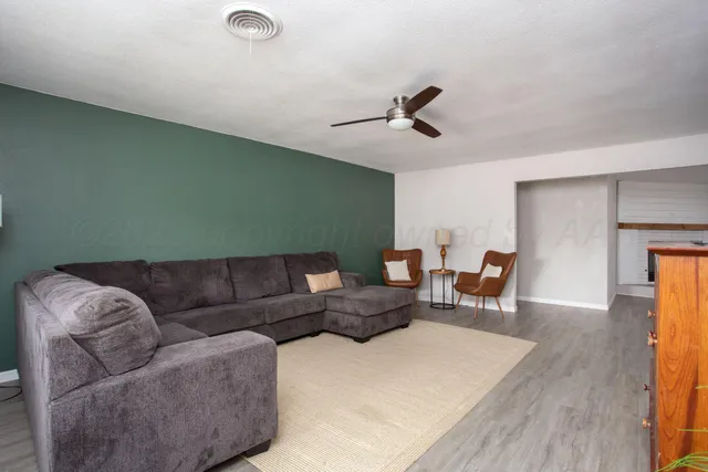 a living room with furniture and a wooden floor