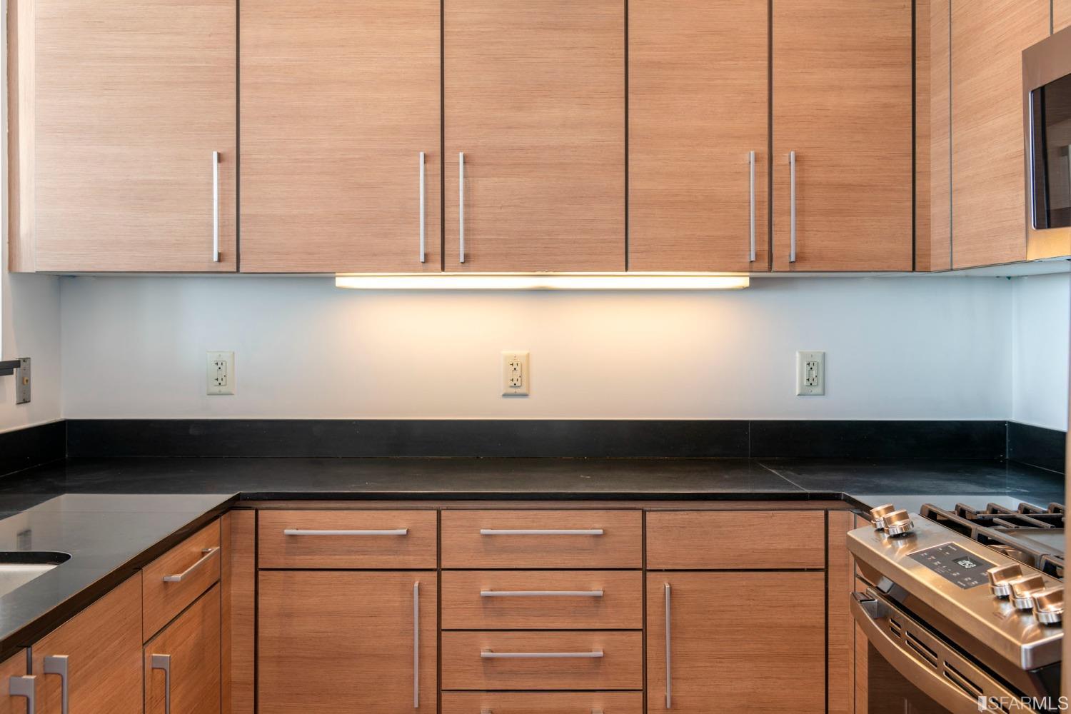 200 2nd Street, Unit 514 Oakland, CA 94607 - Photo 15 of 26 a kitchen with granite countertop white cabinets and black appliances