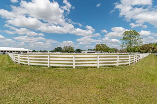 a living room with furniture a lamp and a floor to ceiling window