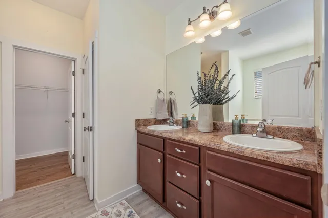 a bathroom with a granite countertop double vanity sink and a mirror