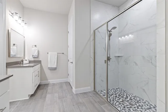 a kitchen with stainless steel appliances a dining table chairs refrigerator and microwave