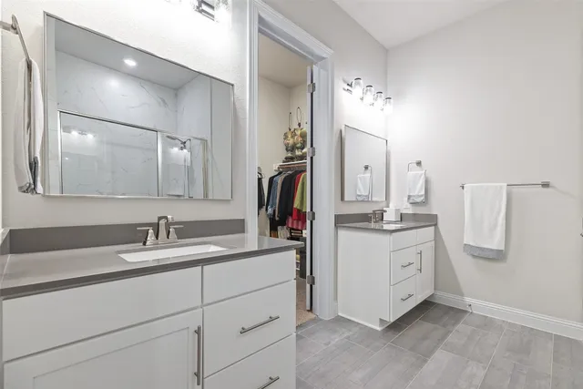 a large white kitchen with a large counter top appliances and cabinets