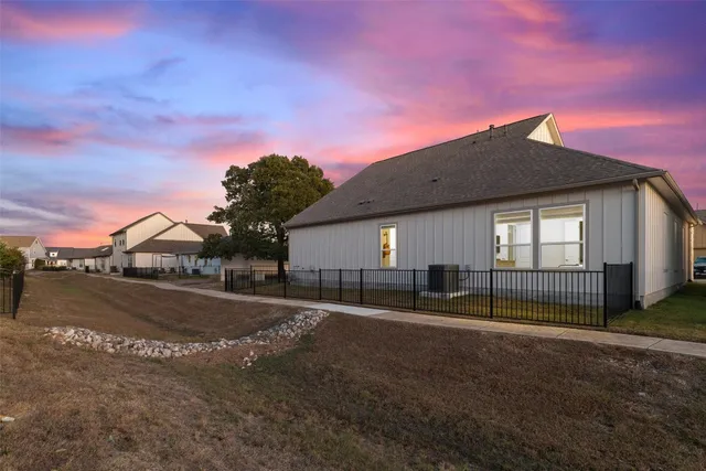 a backyard of a house with fountain table and chairs under an umbrella