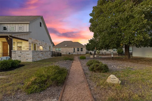a living room with stainless steel appliances granite countertop a table chairs and a rug