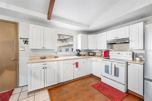 a kitchen with granite countertop appliances sink and cabinets
