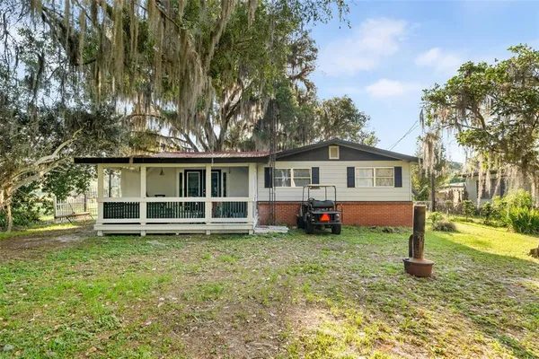 a view of a house with a yard and sitting area