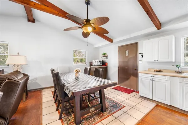 a kitchen with stainless steel appliances granite countertop a dining table chairs and a refrigerator