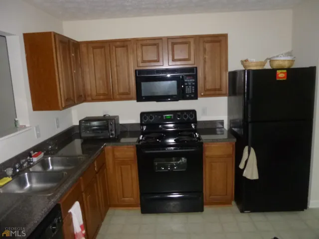 a kitchen with a refrigerator and a stove