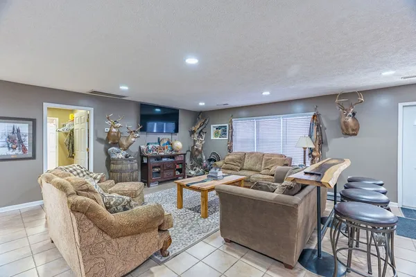 a living room with furniture kitchen view and a chandelier