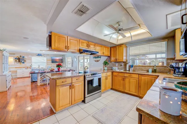 a kitchen with stainless steel appliances granite countertop sink stove top oven and cabinets