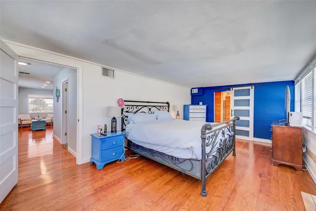 a bedroom with a bed and wooden floor