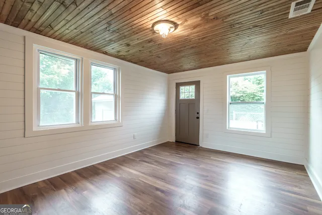 a view of a hallway with wooden floor and glass door
