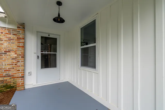 an empty room with wooden floor fireplace and windows