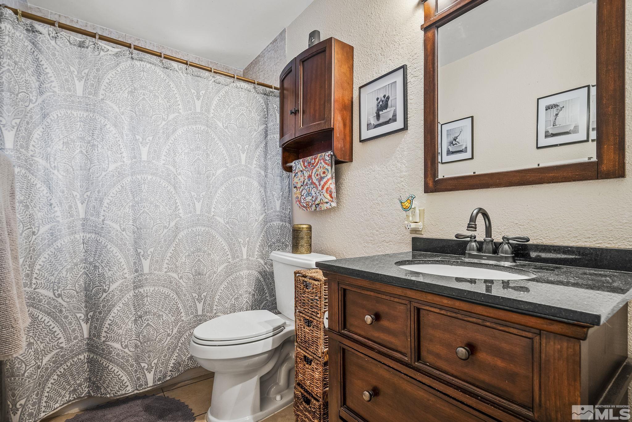 1985 Windsor Way Reno, NV 89503 - Photo 11 of 16 a bathroom with a granite countertop toilet sink and mirror