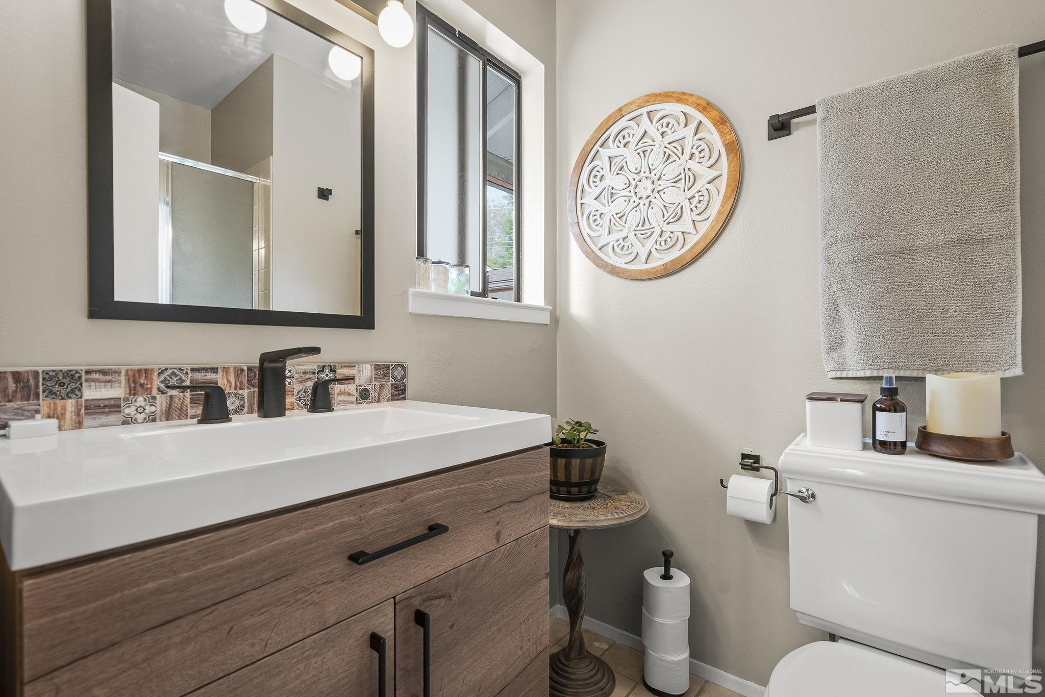 1985 Windsor Way Reno, NV 89503 - Photo 8 of 16 a bathroom with a toilet a sink and a mirror