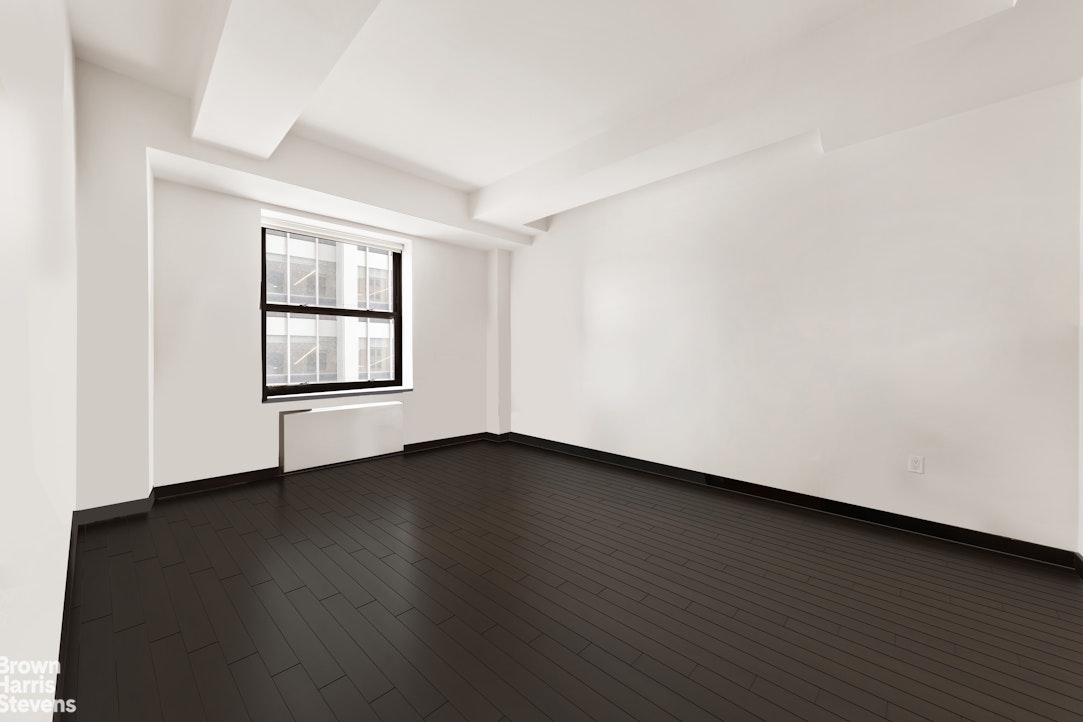 20 Pine Street, Unit 2706 Manhattan, NY 10005 - Photo 4 of 18 an empty room with wooden floor and windows
