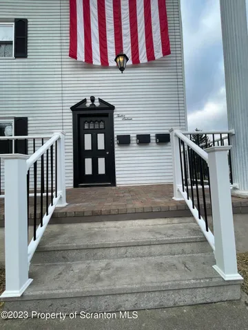a view of an empty room with wooden floor and windows