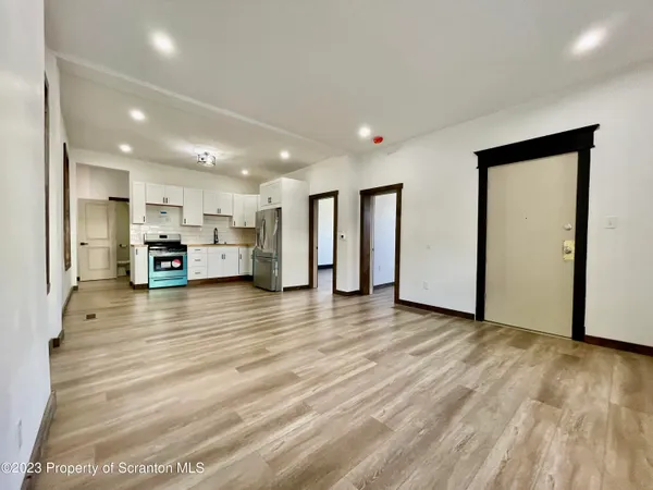 a view of a room with wooden floor and small window