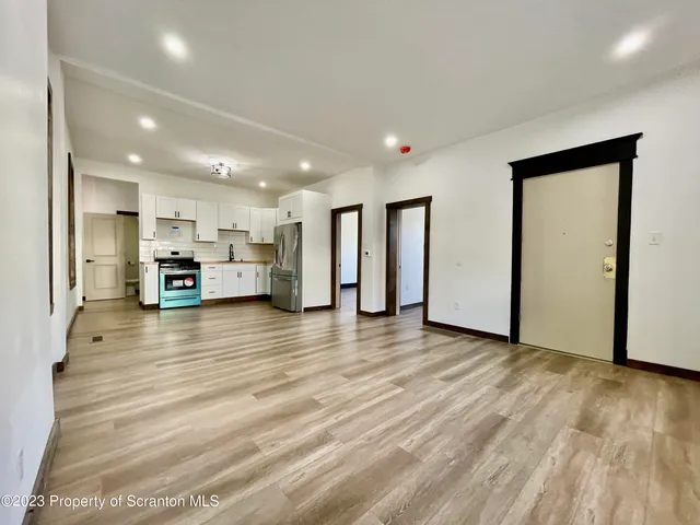 a view of a room with wooden floor and small window
