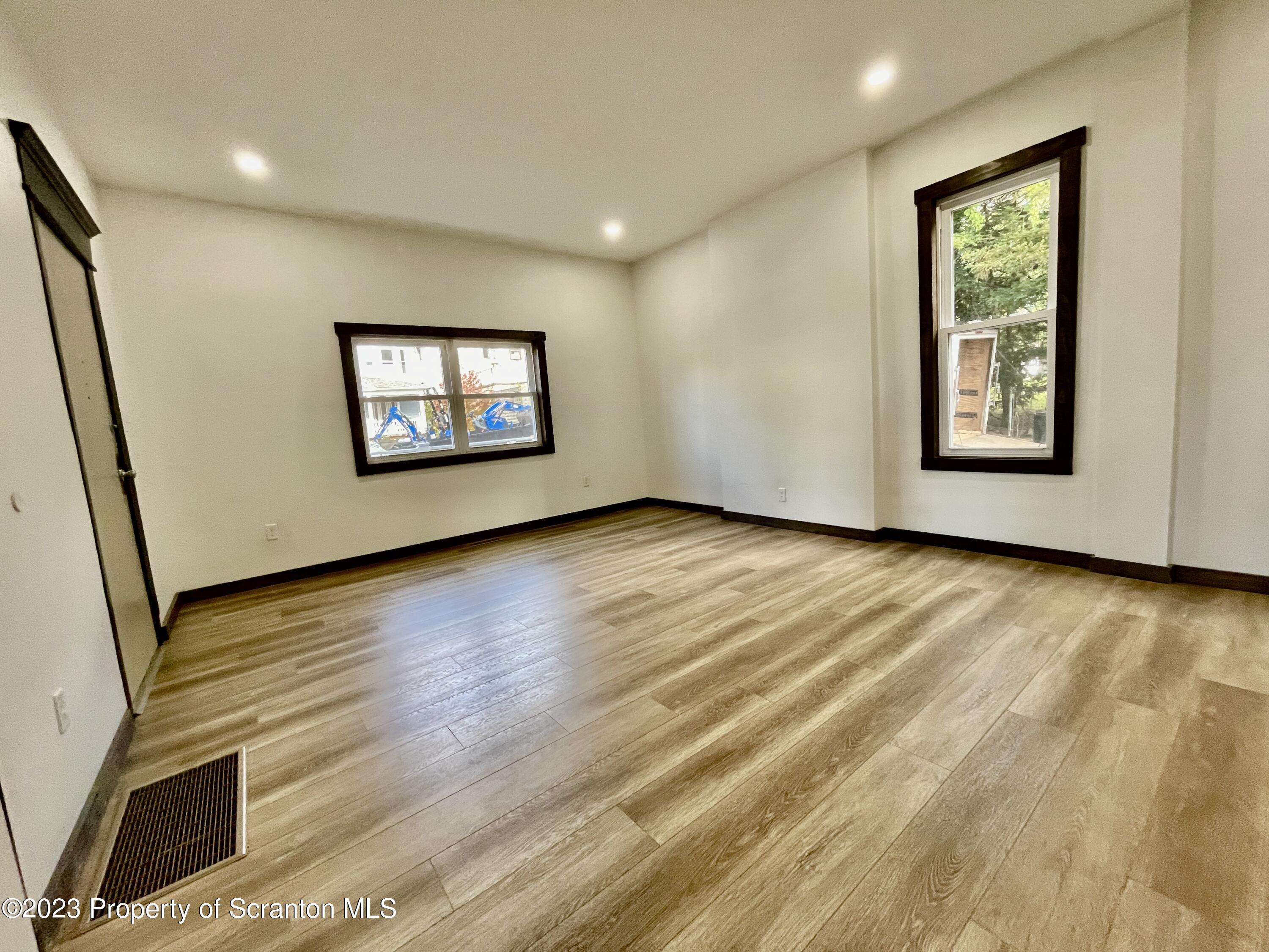 1216 Marion Street Scranton, PA 18509 - Photo 18 of 37 a view of an empty room with wooden floor and a window