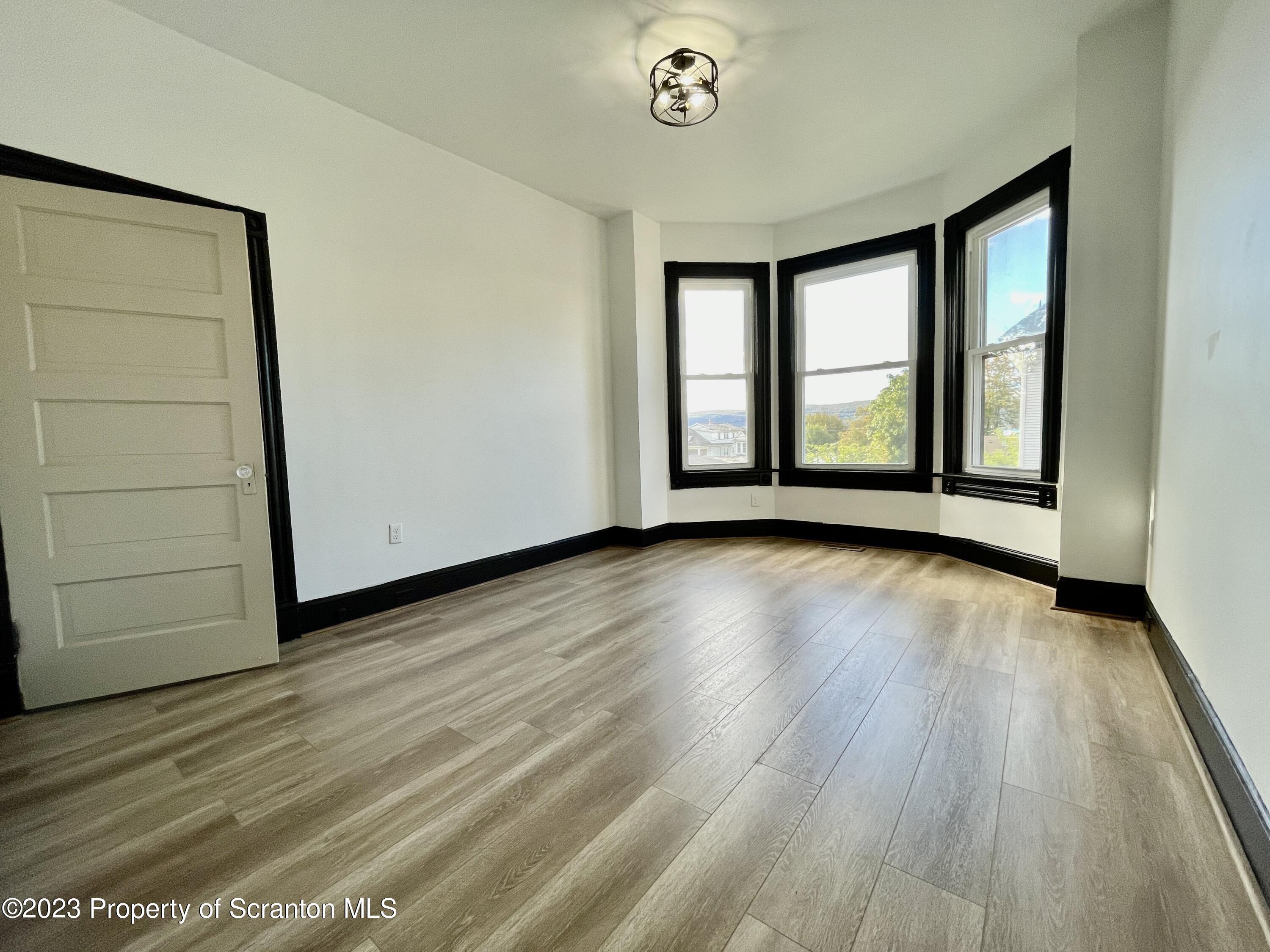 1216 Marion Street Scranton, PA 18509 - Photo 20 of 37 an empty room with wooden floor and windows