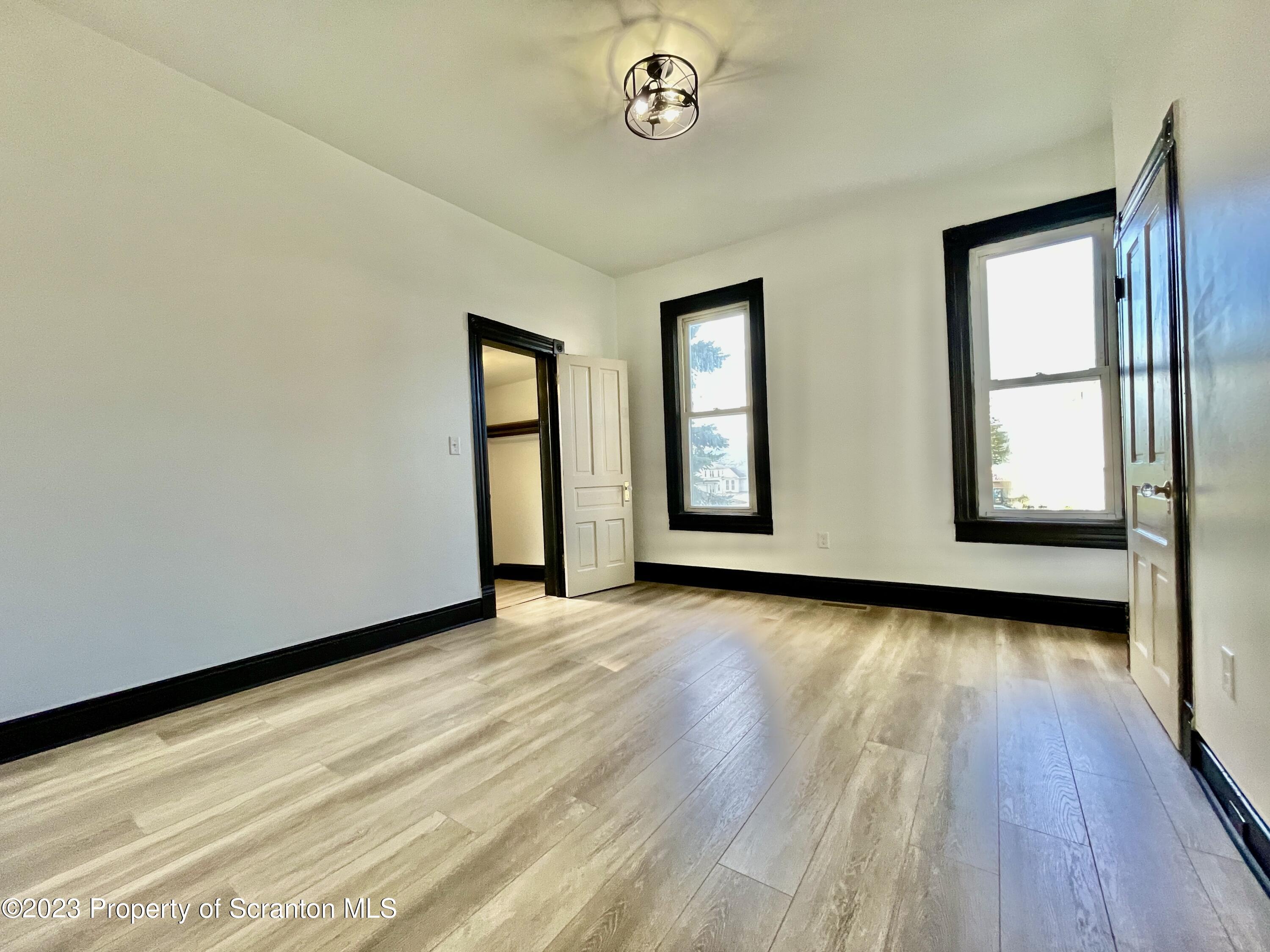 1216 Marion Street Scranton, PA 18509 - Photo 23 of 37 an empty room with wooden floor and windows