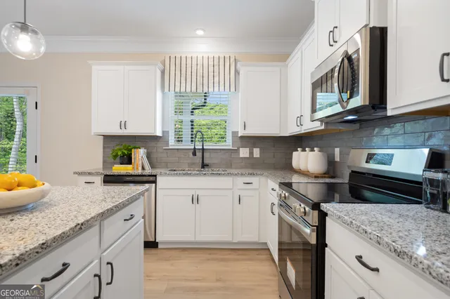 a kitchen with stainless steel appliances granite countertop a sink stove and cabinets
