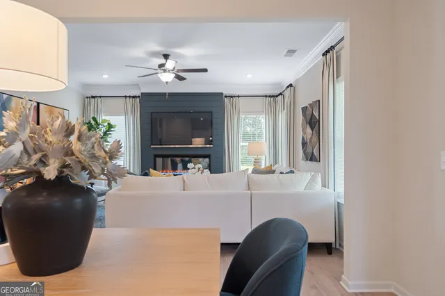 a living room with furniture a flat screen tv and a large window