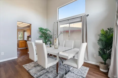 a dining room with furniture potted plants and wooden floor