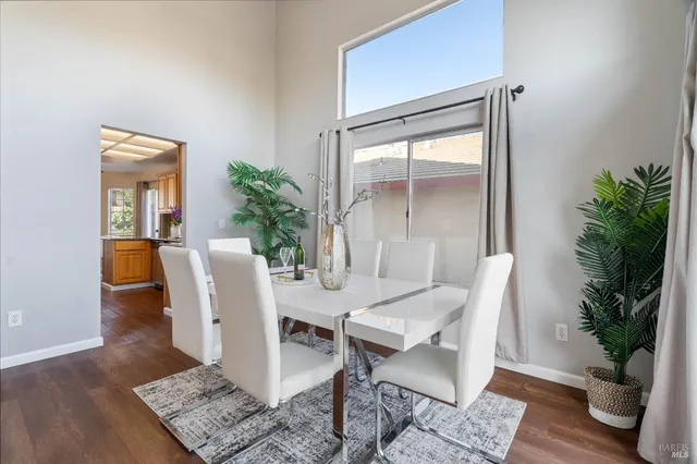 a dining room with furniture potted plants and wooden floor