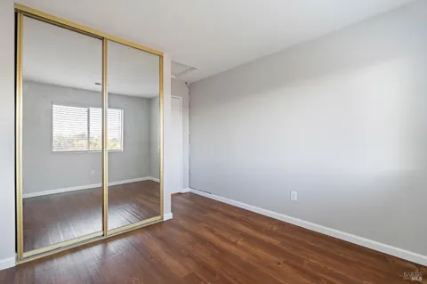 an empty room with wooden floor and sliding door