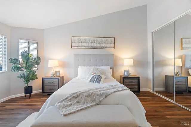 a bedroom with a large bed and wooden floor