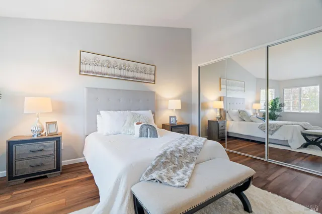 a bedroom with a bed a lamp and a large window