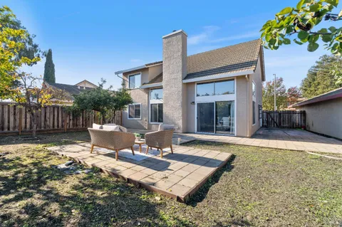 a view of a house with backyard and sitting area