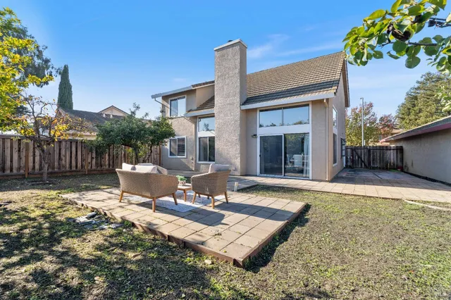a view of a house with backyard and sitting area
