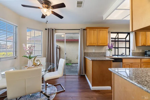 a kitchen with granite countertop a sink a counter top space and living room area