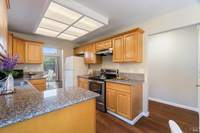 a kitchen with granite countertop wooden floors and sink