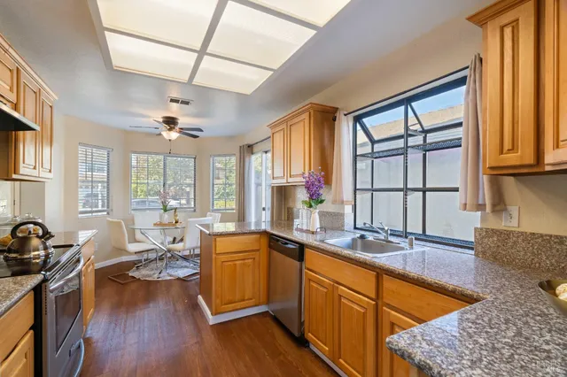 a kitchen with stainless steel appliances granite countertop sink stove top oven and cabinets