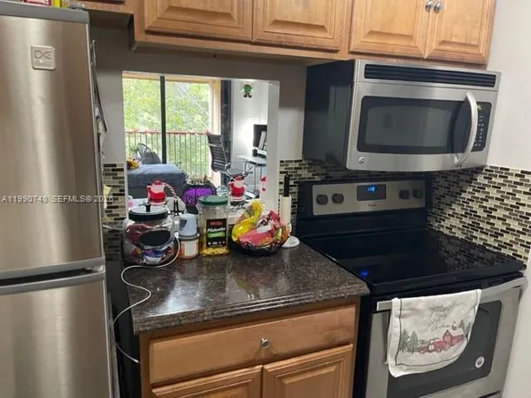 a kitchen with a refrigerator and a stove