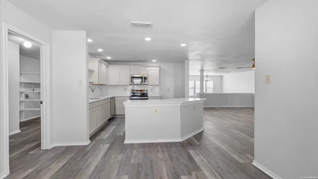 a kitchen with white cabinets and white appliances