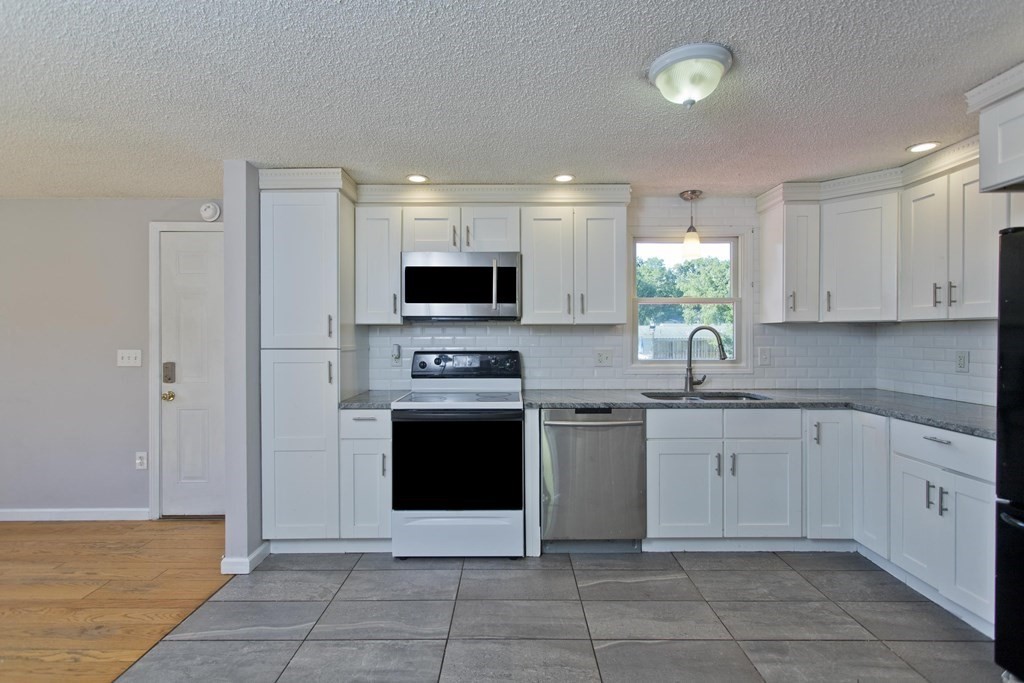 25 Driftwood Road Springfield, MA 01128 - Photo 8 of 21 a kitchen with stainless steel appliances granite countertop a stove a sink and a microwave