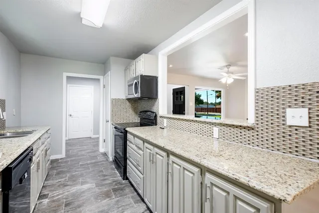 a kitchen with a sink stove and cabinets