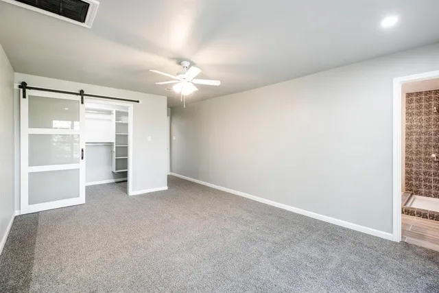 an empty room with a window and a kitchen
