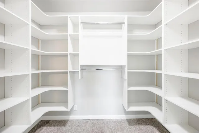 a view of walk in closet with empty racks