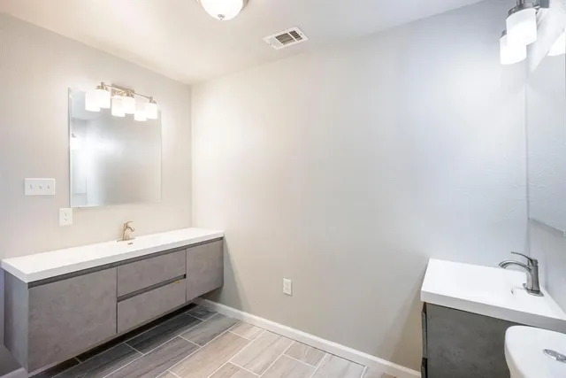 a bathroom with a double vanity sink mirror and toilet